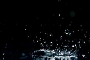 pioggia. acqua goccioline, spruzzi su un' nero sfondo foto