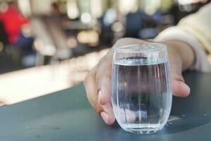 Tenere un' bicchiere di acqua con copia spazio foto