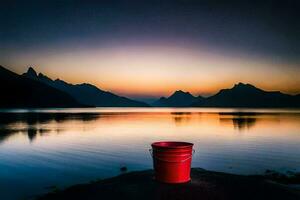 un' rosso secchio si siede su il riva di un' lago a tramonto. ai-generato foto