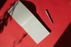 un Aperto taccuino con un' penna bugie su un' colorato rosso sfondo. ufficio forniture. posto per testo foto