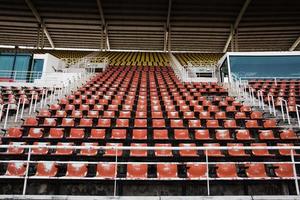 sedili di plastica vuoti e vecchi rossi nello stadio. foto