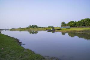 canale con verde erba e vegetazione riflessa nel il acqua vicino padma fiume nel bangladesh foto