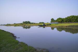 canale con verde erba e vegetazione riflessa nel il acqua vicino padma fiume nel bangladesh foto