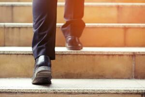 uomo d'affari moderno che lavora le gambe ravvicinate che salgono le scale nella città moderna. nell'ora di punta per lavorare in ufficio in fretta. durante la prima mattina di lavoro. scala. focalizzazione morbida. foto