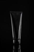 tubo cosmetico prodotto nero lucido su sfondo nero