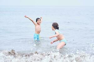 un' ragazzo e un' ragazza siamo avendo divertimento giocando nel il mare. foto