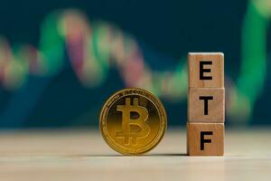 bitcoin oro moneta parole etf di legno blocchi su righe pila monete e sfocato grafico sfondo, criptovaluta bitcoin dimezzare concetto. il bitcoin etf quale si riferisce per scambio scambiato finanziare. foto