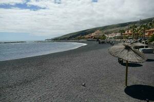 un' spiaggia con ombrelli e persone su esso foto