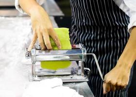 chef che prepara impasti per pasticceria, pasta fresca e macchina per la pasta in cucina foto