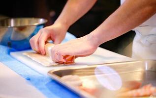 mani dello chef che preparano cibo giapponese, chef che prepara sushi foto