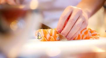 mani dello chef che preparano cibo giapponese, chef che prepara sushi foto