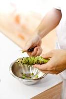 chef di sushi che grattugia wasabi fresco, radice di wasabi fresca foto