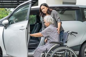 aiutare e sostenere la donna anziana asiatica raggiungere la sua auto. foto