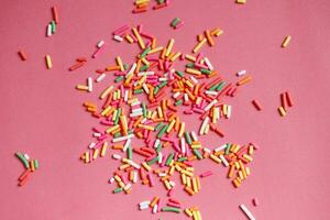 condimenti per ciambelle, dolci e ghiaccio crema su rosa sfondo. foto