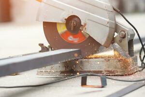 un' lavoratore taglio acciaio con un' acciaio taglio macchina acceso a un' costruzione luogo. foto