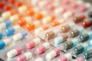 primo piano farmaci antibiotici pillole medicina in blister. sfondo colorato farmacia pillole antibatteriche. capsula pillola farmaco resistenza antimicrobica. industria farmaceutica foto