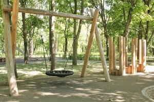 di legno terreno di gioco fatto di naturale eco-friendly Materiale nel pubblico città parco. moderno sicurezza bambini all'aperto attrezzatura. concetto di sostenibile stile di vita e ecologia. bambini riposo e Giochi su Aperto aria foto