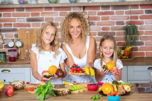 madre e figlie cucinando insieme nel il cucina. salutare cibo concetto. ritratto di contento famiglia con fresco frullati. contento sorelle. foto