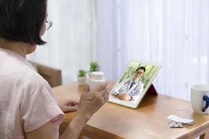 la donna anziana consulta il medico online tramite videochiamata foto