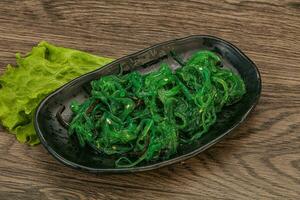 insalata di alghe chuka verde isolata su sfondo bianco vista dall'alto. Salat di alghe di mare wakame foto