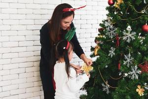 madre e figlio asiatici decorano insieme l'albero di Natale