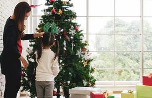 madre e figlio asiatici decorano insieme l'albero di Natale