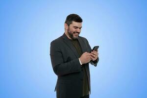 contento uomo d'affari Tenere smartphone sotto chiaro blu cielo foto