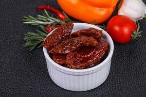 pomodori secchi in una ciotola con olio d'oliva foto