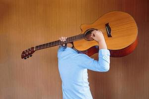 ragazzo che suona la chitarra classica con divertimento foto