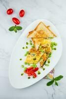 prima colazione di uova e verdure con ciliegia pomodori e fette di pane nel un' bianca piatto superiore Visualizza foto