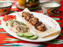 pollo kebab carbone grigliato pollo servito.al.seno con la verdura, sottaceto cipolle, lavash pane e orientale salsa foto