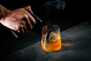 aromatico cocktail con un' rametto di pino aghi e il giro ghiaccio su un' buio sfondo, lato Visualizza foto