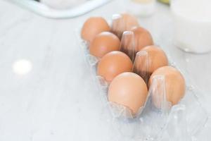 primo piano di una dozzina di uova sul tavolo per preparare la cottura in cucina