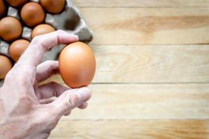 uomo che tiene un uovo di gallina fresco con spazio di copia foto