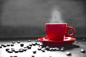 tazza di caffè rossa con fumo e chicco di caffè foto