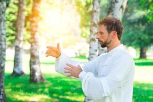 un istruttore pratica di tai chi chuan nel parco. foto