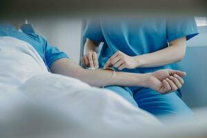 donne asiatico medici hold il paziente mano e incoraggiare e fornire medico consigli mentre controllo il paziente Salute nel letto. concetto di cura e compassione, prenatale cura, minacciato aborto foto
