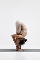 giovane attraente donna praticante yoga isolato su bianca sfondo. concetto di salutare vita e naturale equilibrio fra corpo e mentale sviluppo foto