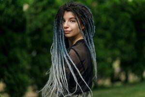 allegro caucasico ragazza guardare a il telecamera e sorridente modello con dreadlocks foto