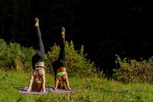 fitness donne nel triangolo posa mentre praticando yoga a un' parco. foto