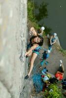 un' ragazza si arrampica un' roccia. donna impegnato nel estremo sport. foto