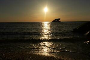 tramonto spiaggia nel capo Maggio nuovo maglia dove voi può ottenere un' grande Visualizza di il sole andando giù attraverso il oceano e il baia. il riflessione di il sole su il acqua con il affondata nave sembra così Bellissima. foto