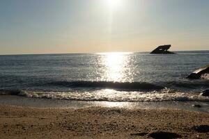 tramonto spiaggia nel capo Maggio nuovo maglia dove voi può ottenere un' grande Visualizza di il sole andando giù attraverso il oceano e il baia. il riflessione di il sole su il acqua con il affondata nave sembra così Bellissima. foto