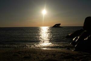 tramonto spiaggia nel capo Maggio nuovo maglia dove voi può ottenere un' grande Visualizza di il sole andando giù attraverso il oceano e il baia. il riflessione di il sole su il acqua con il affondata nave sembra così Bellissima. foto