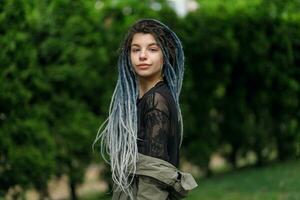 allegro caucasico ragazza guardare a il telecamera e sorridente modello con dreadlocks foto