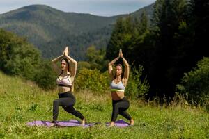 fitness donne nel triangolo posa mentre praticando yoga a un' parco. foto