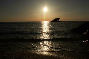 tramonto spiaggia nel capo Maggio nuovo maglia dove voi può ottenere un' grande Visualizza di il sole andando giù attraverso il oceano e il baia. il riflessione di il sole su il acqua con il affondata nave sembra così Bellissima. foto