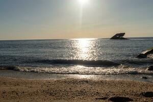 tramonto spiaggia nel capo Maggio nuovo maglia dove voi può ottenere un' grande Visualizza di il sole andando giù attraverso il oceano e il baia. il riflessione di il sole su il acqua con il affondata nave sembra così Bellissima. foto