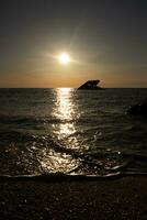 tramonto spiaggia nel capo Maggio nuovo maglia dove voi può ottenere un' grande Visualizza di il sole andando giù attraverso il oceano e il baia. il riflessione di il sole su il acqua con il affondata nave sembra così Bellissima. foto