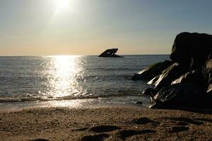 tramonto spiaggia nel capo Maggio nuovo maglia dove voi può ottenere un' grande Visualizza di il sole andando giù attraverso il oceano e il baia. il riflessione di il sole su il acqua con il affondata nave sembra così Bellissima. foto